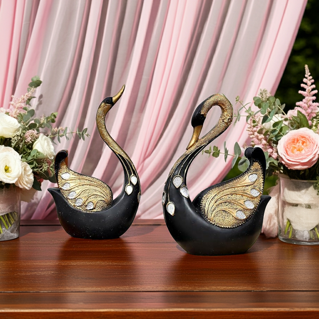 SwaSha black and gold resin swan sculptures, elegant home decor pair with intricate details on a wooden surface